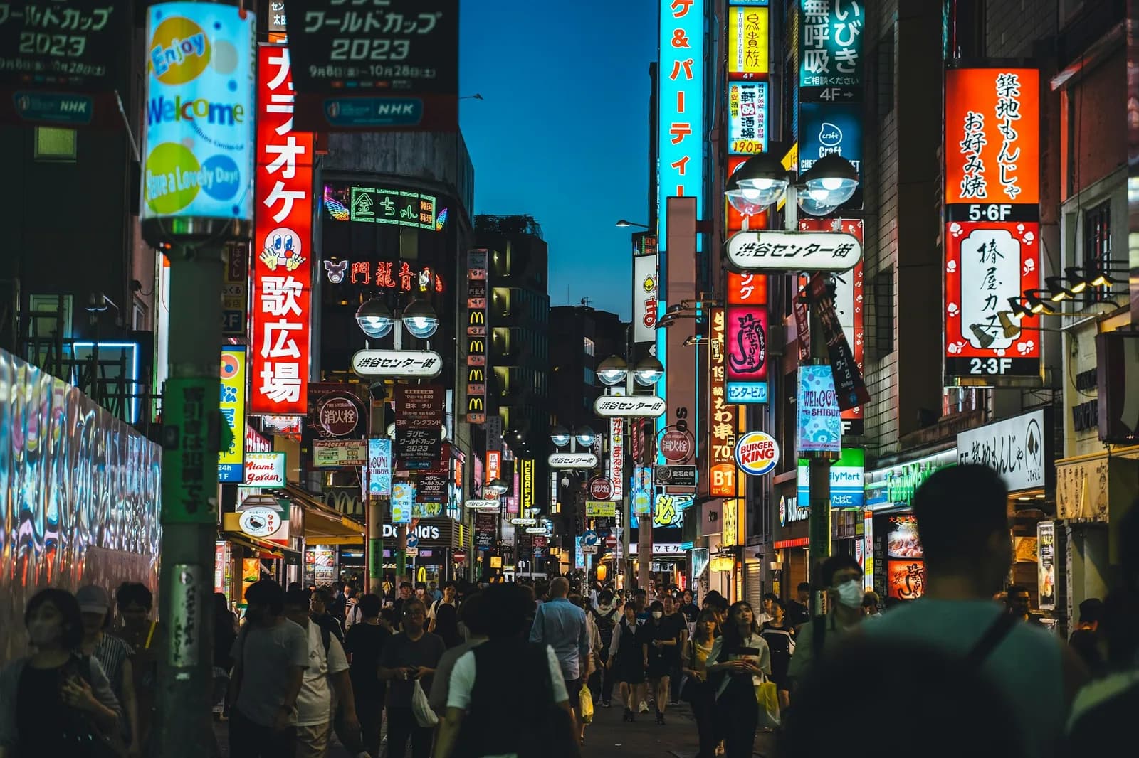 A Japanese city street at night lit by neon signs
